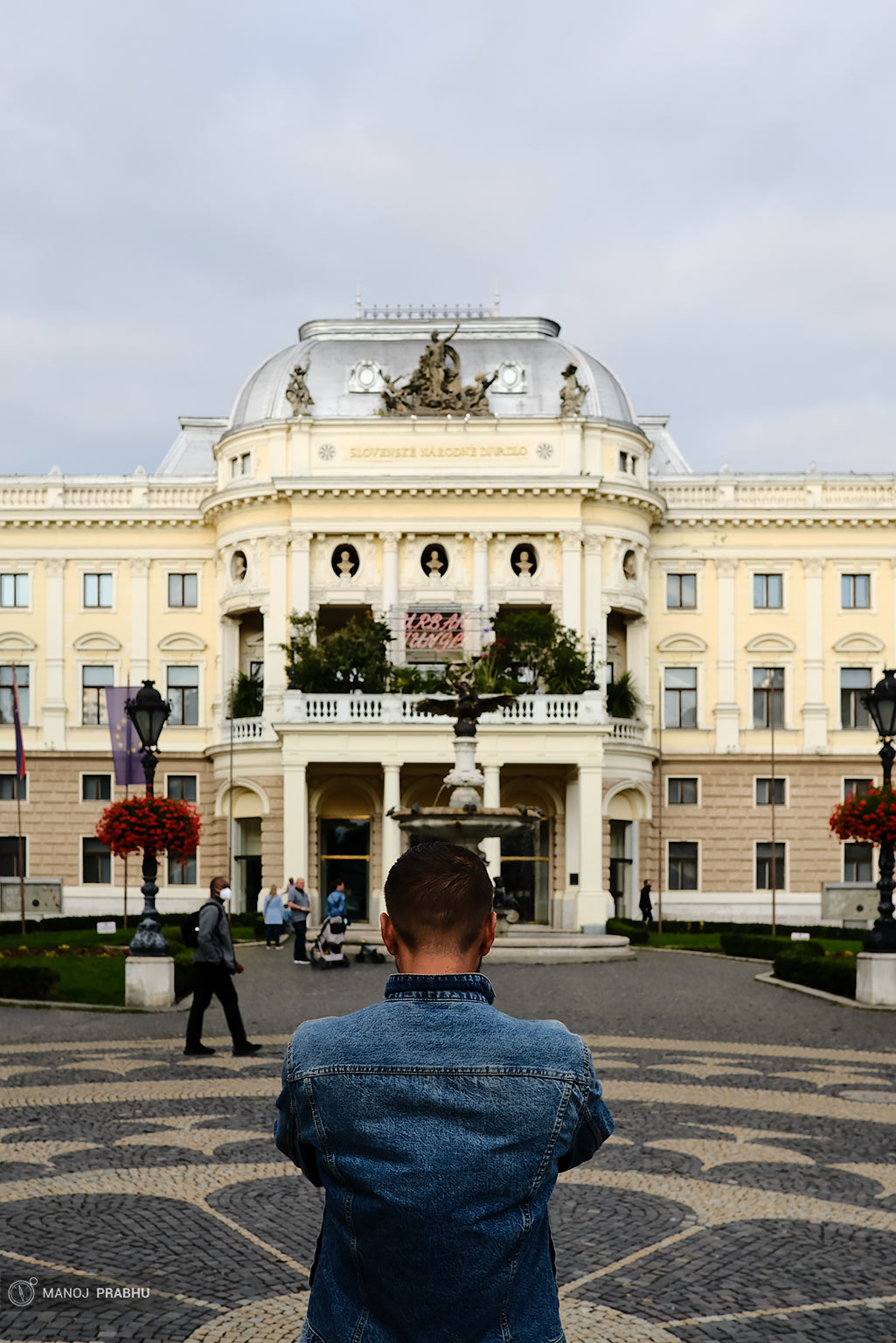 A man taking a photograph of a building. (Shot on Fujifilm X-Pro2 using Kodak Ektar 100 film simulation recipe)