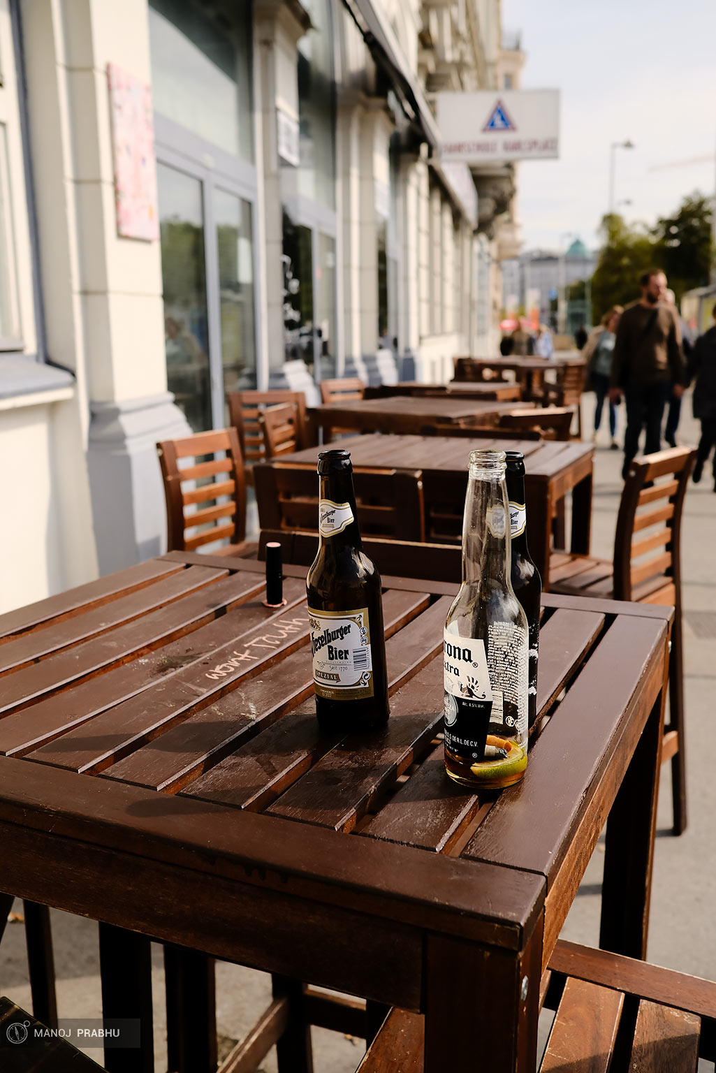 Empty beer bottles on a table of an outdoor cafe. (Shot on Fujifilm X-Pro2 using Kodak Ektar 100 film simulation recipe)
