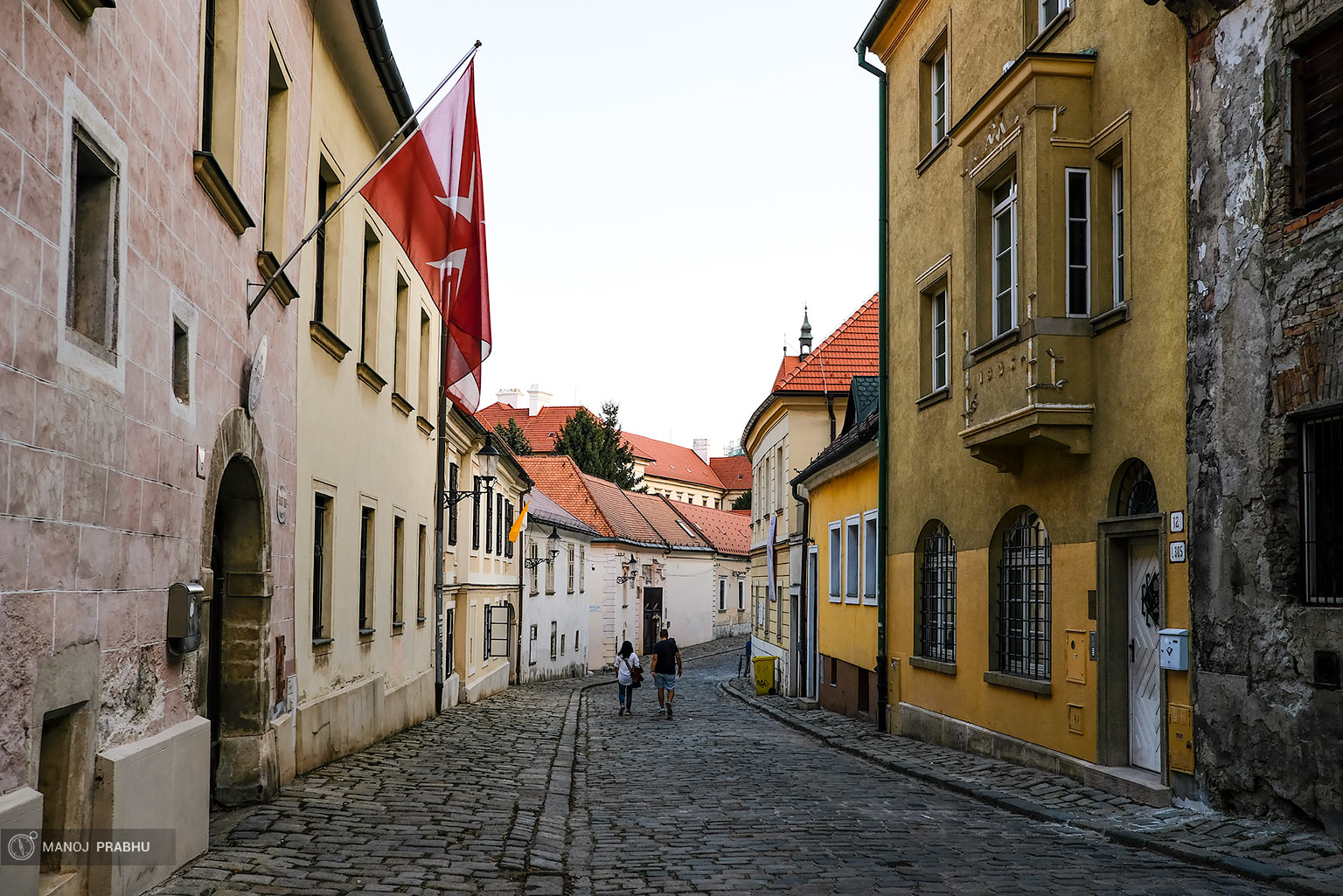 A couple walking down a cobbled street in Bratislava. (Shot on Fujifilm X-Pro2 using Kodak Ektar 100 film simulation recipe)